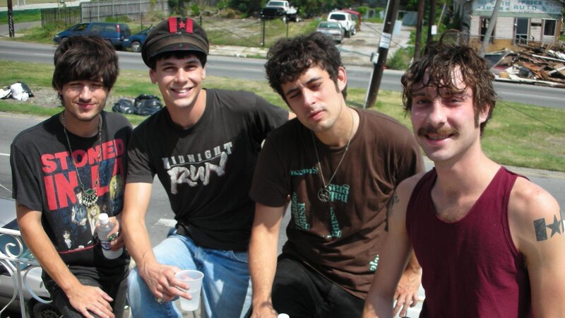 four young men posing outdoors