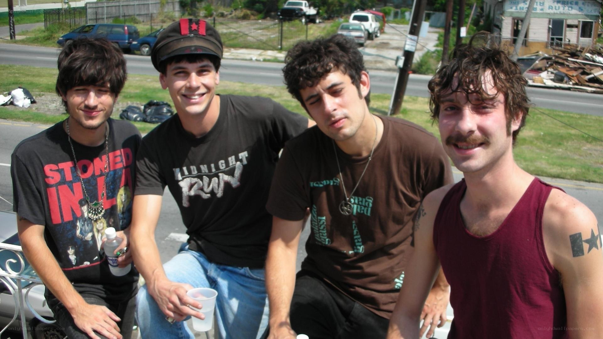 four young men posing outdoors