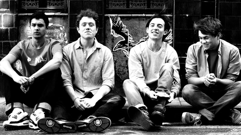 four young men sitting on steps