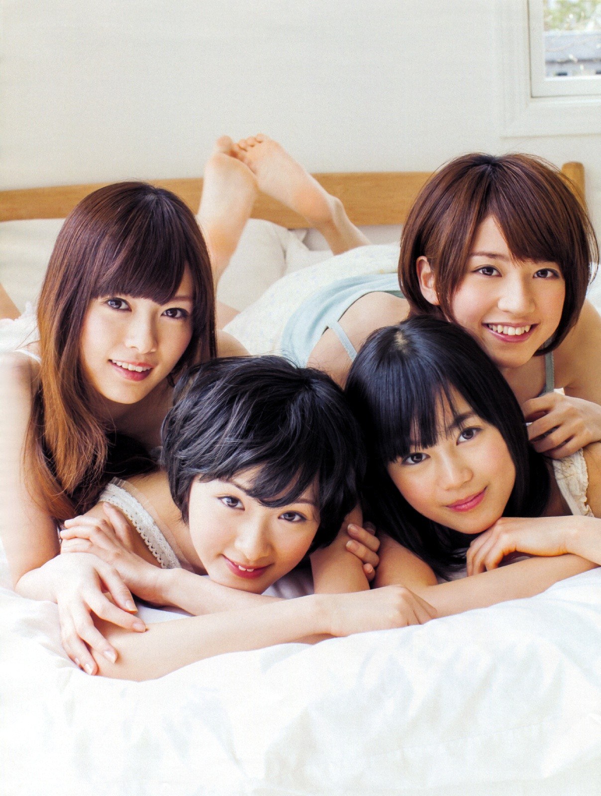 four young women on a bed