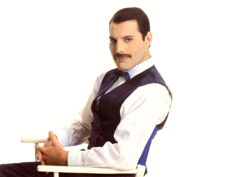 Freddie Mercury seated in a chair