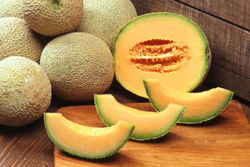 Fresh cantaloupes on wooden surface
