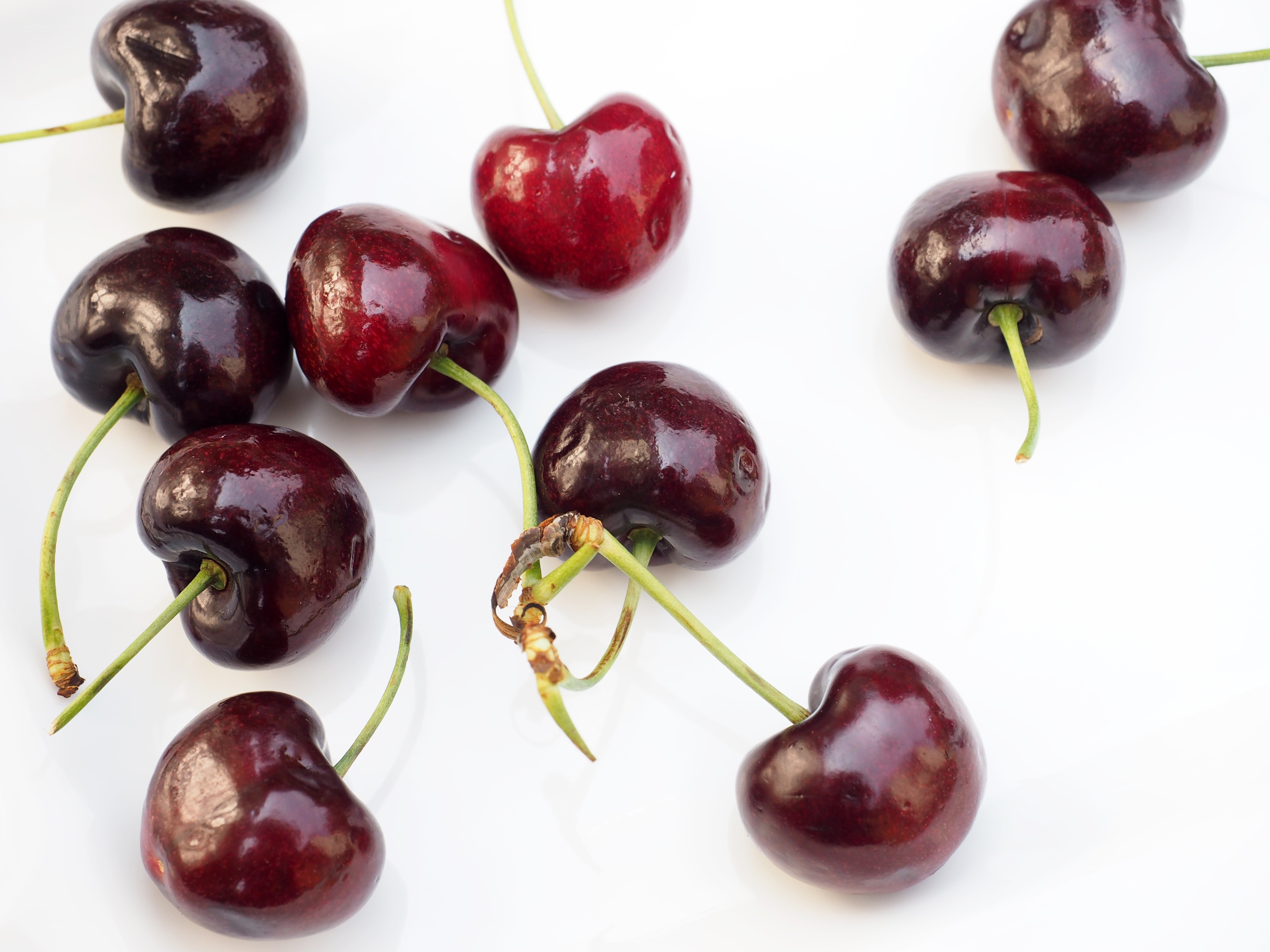 Fresh cherries on white surface