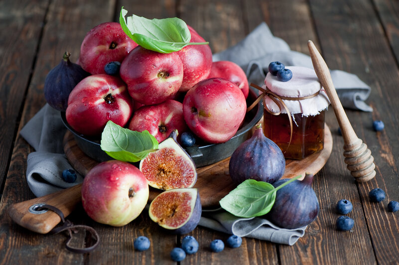 Fresh fruit and honey on wood
