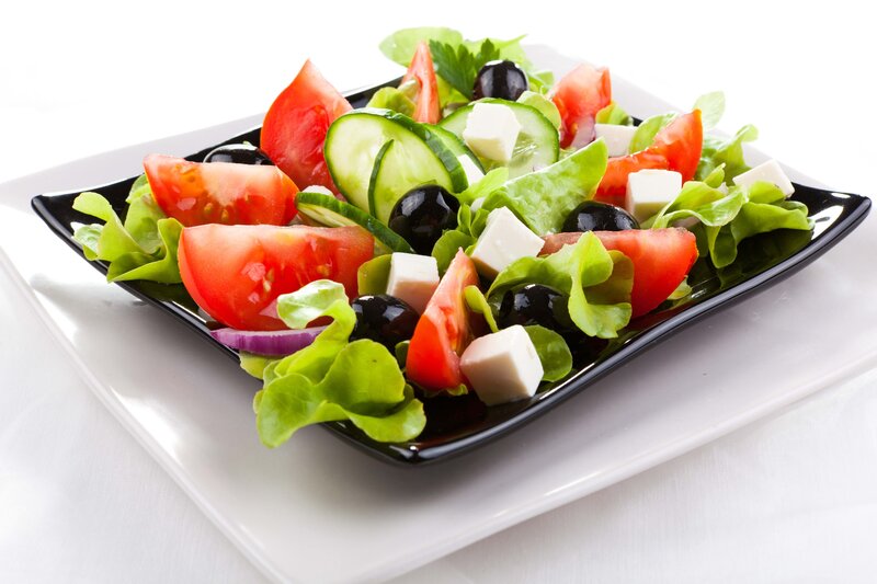 fresh greek salad on black plate