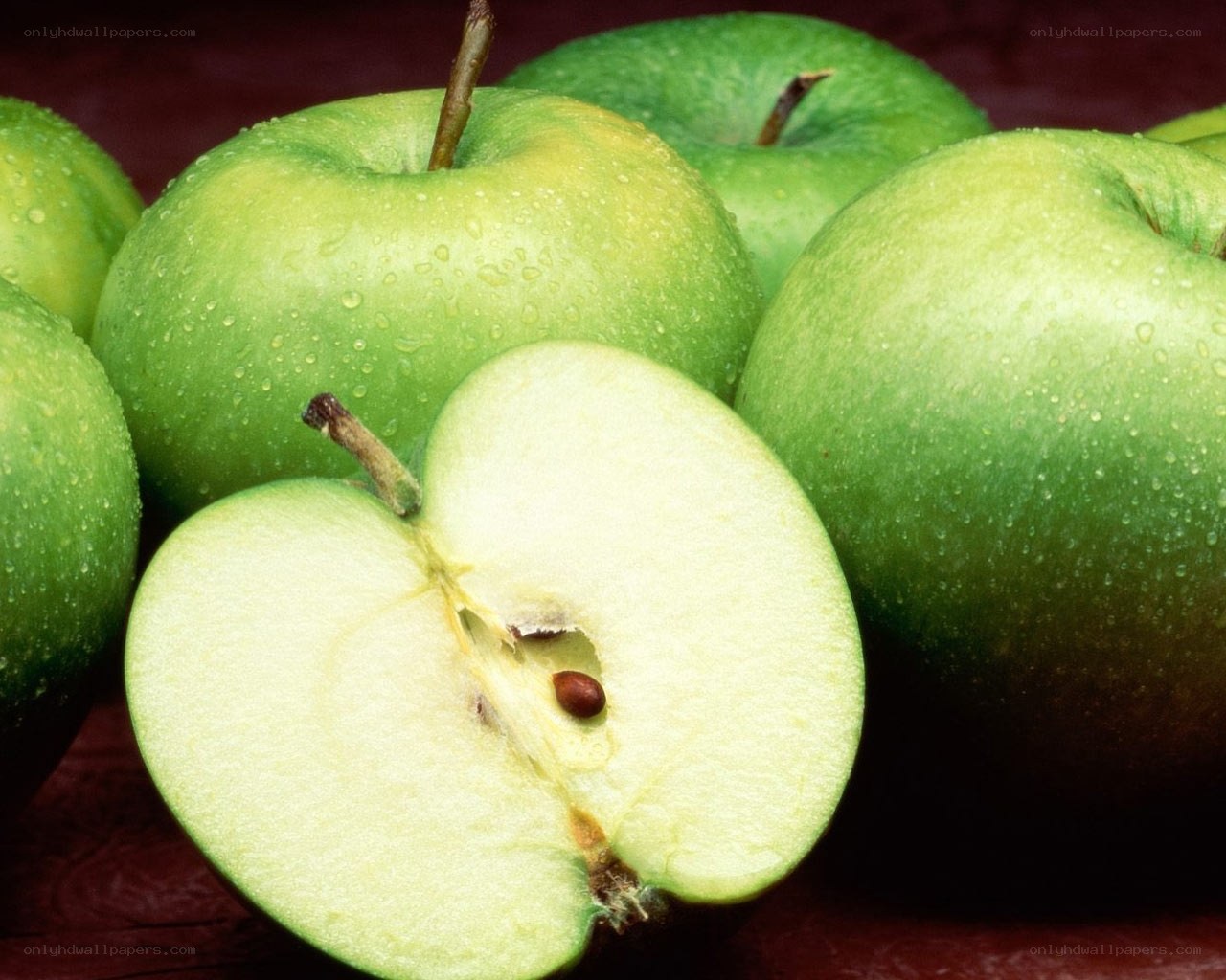 Fresh green apples with one sliced