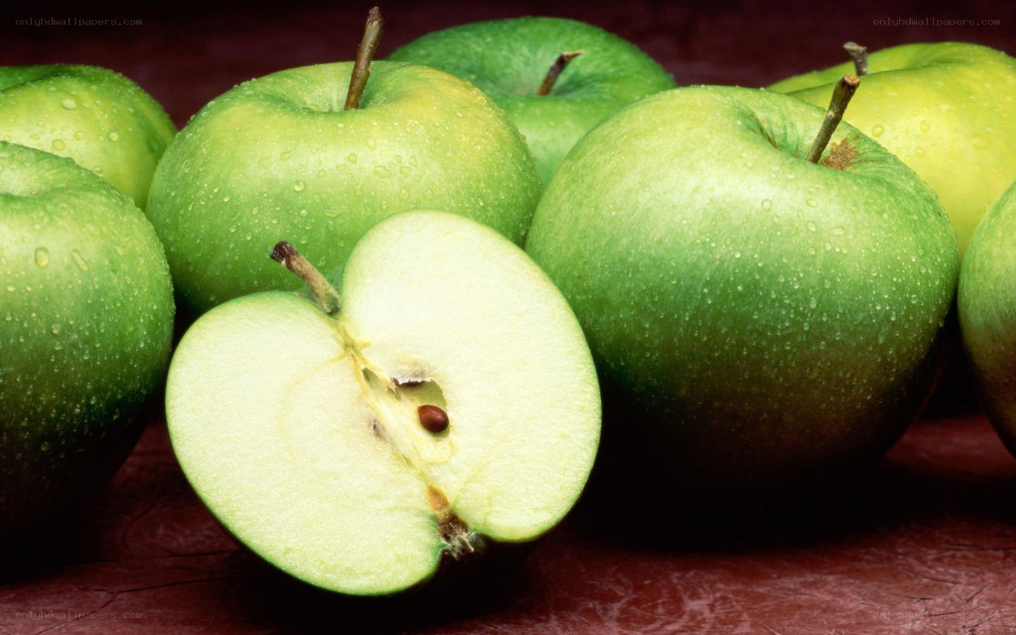 Fresh green apples with one sliced