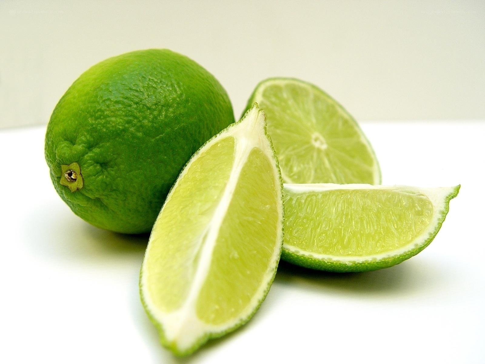 Fresh limes on white surface