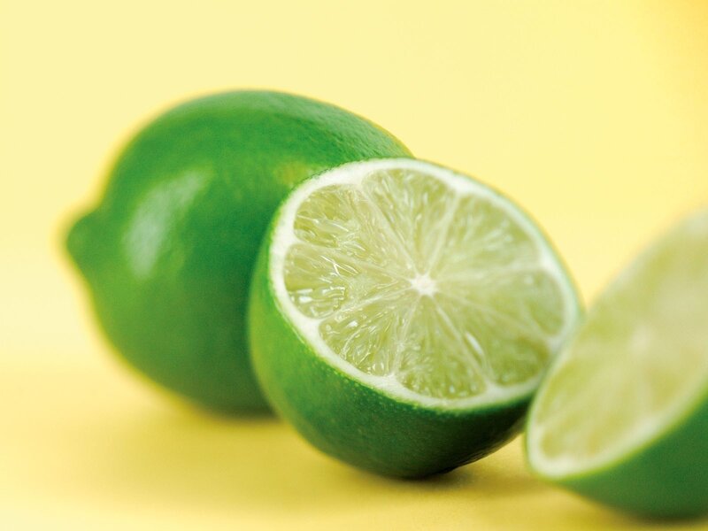 Fresh limes on yellow background