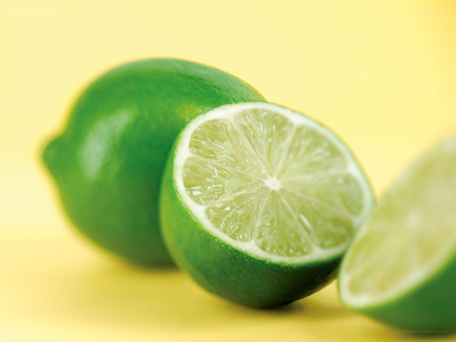 Fresh limes on yellow background