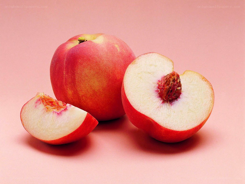 Fresh peaches on pink