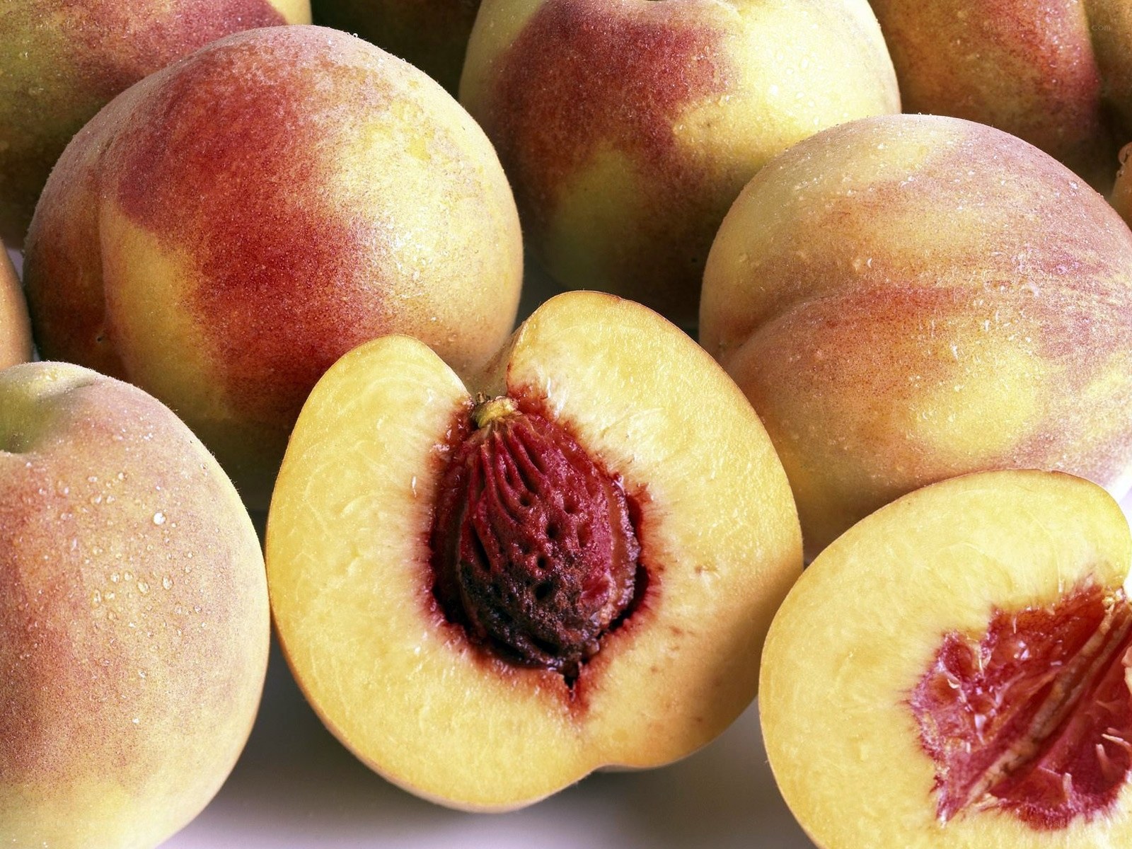 Fresh peaches with one cut in half