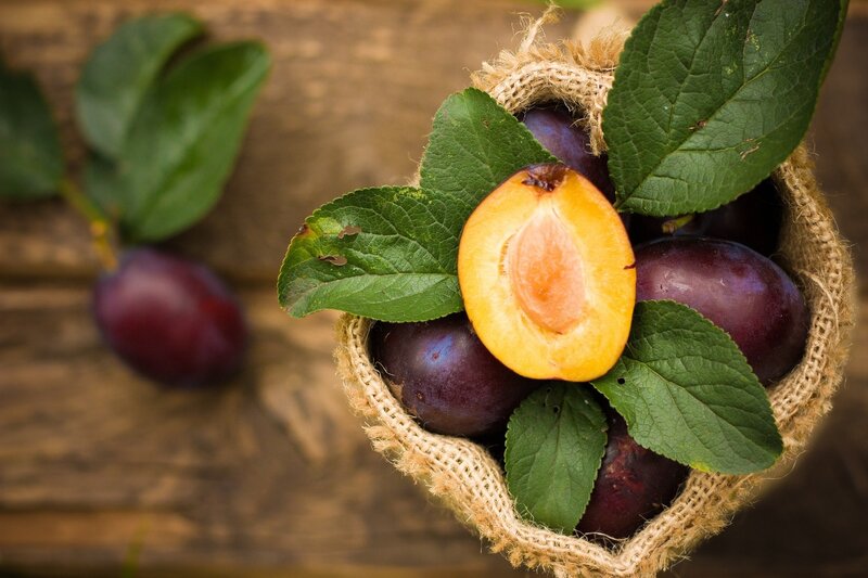 Fresh plums in a burlap basket