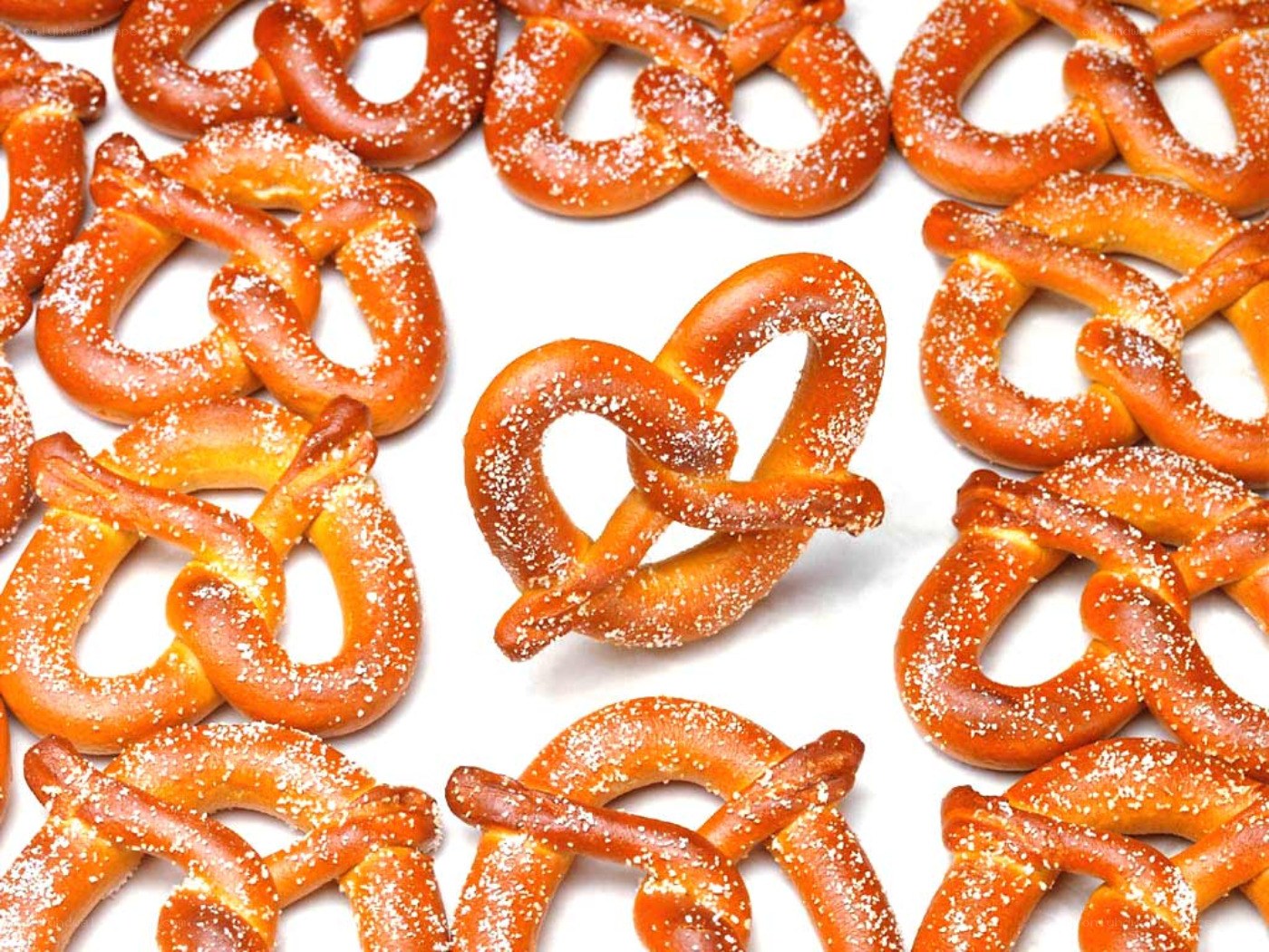 Fresh pretzels on white surface