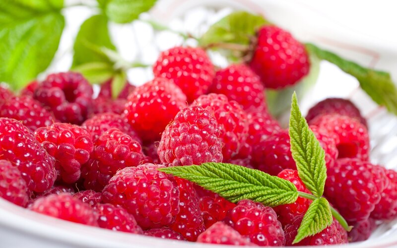 Fresh raspberries with green leaves