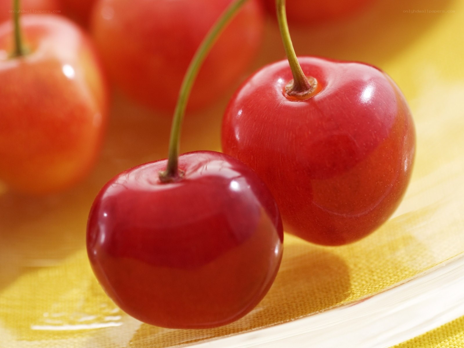 Fresh red cherries on yellow surface