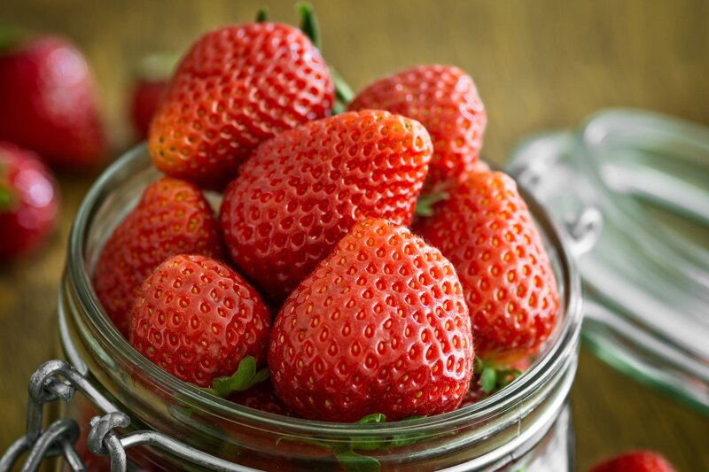 Fresh strawberries in a glass jar