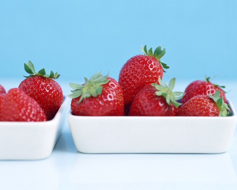 Fresh strawberries in white bowls