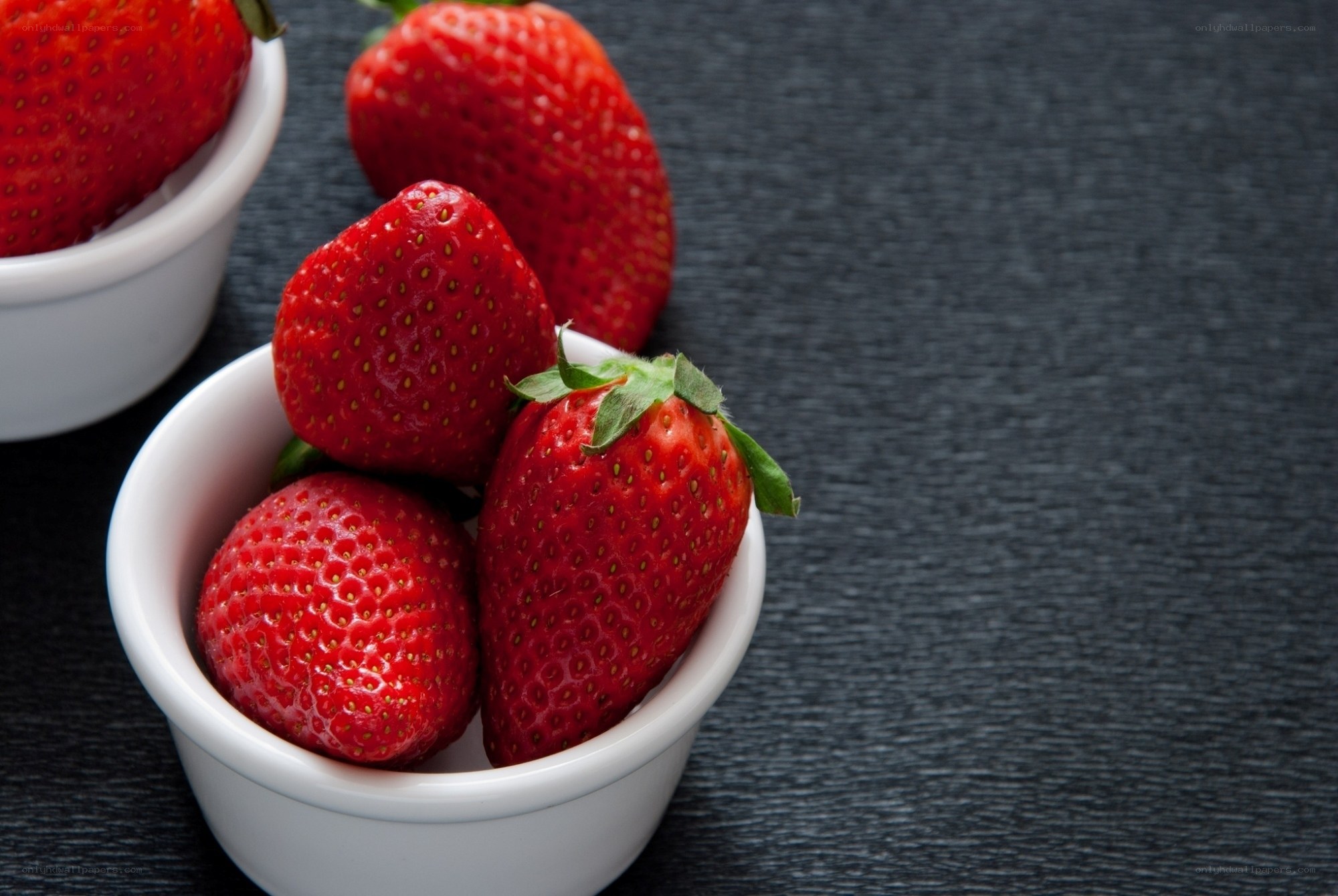 Fresh strawberries in white bowls