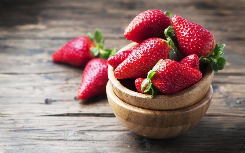 Fresh strawberries in wooden bowls