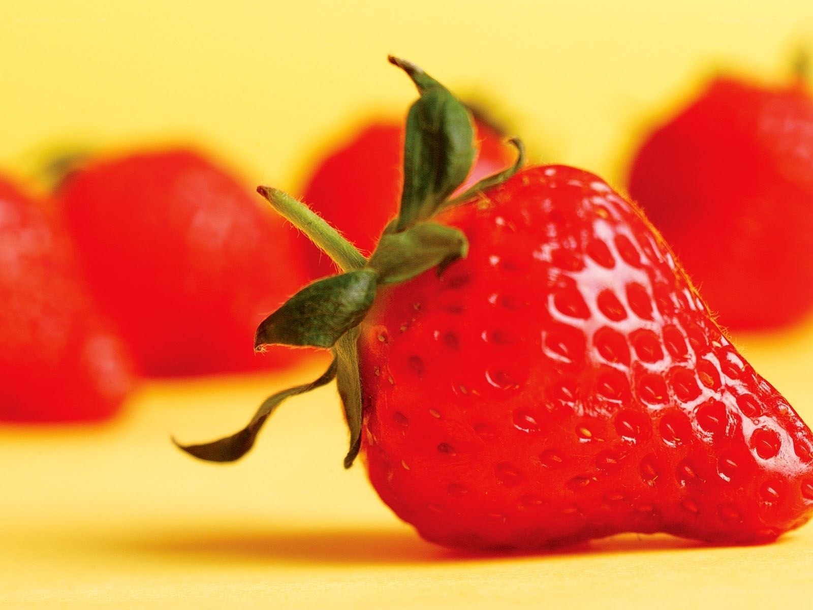 Fresh strawberry on yellow background