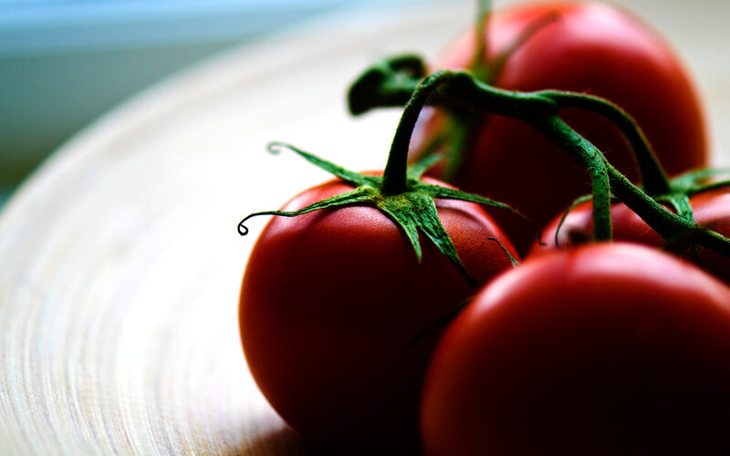 Fresh tomatoes on a wooden surface