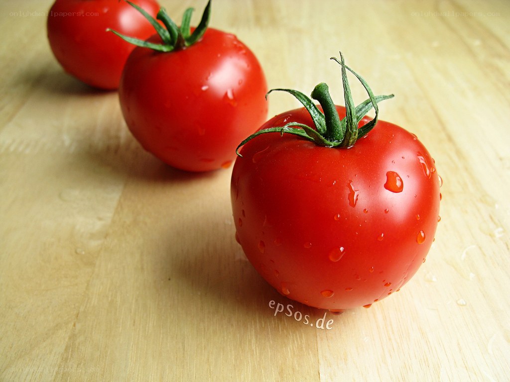 Fresh tomatoes on wooden surface