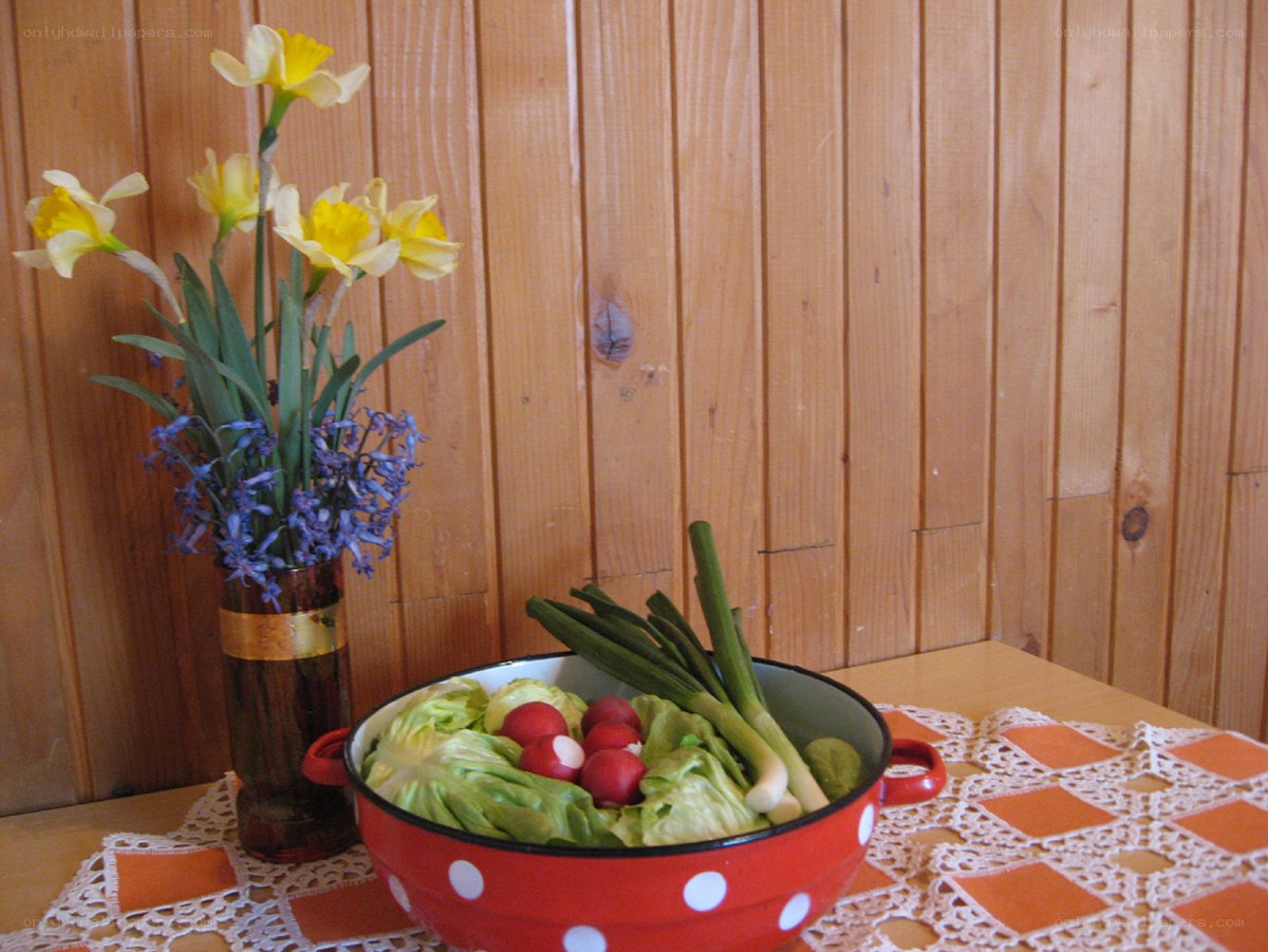 Fresh vegetables and flowers on table