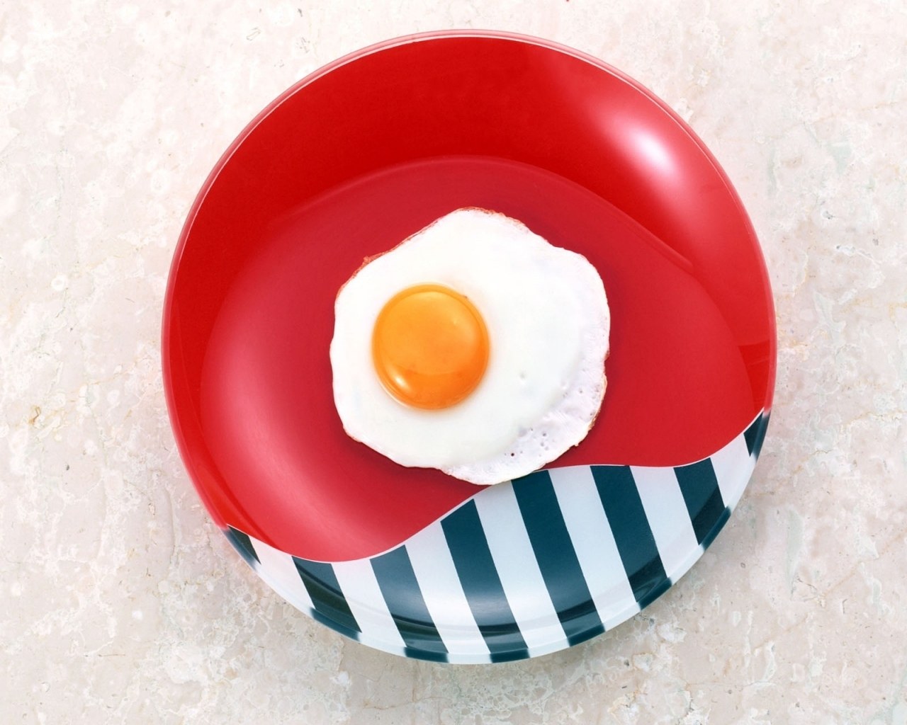 Fried egg on red plate
