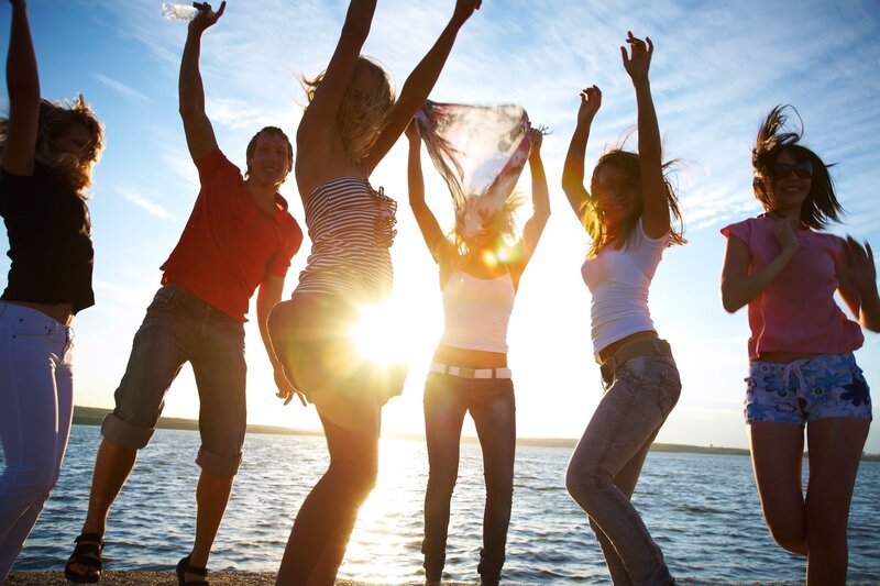 friends dancing by the water