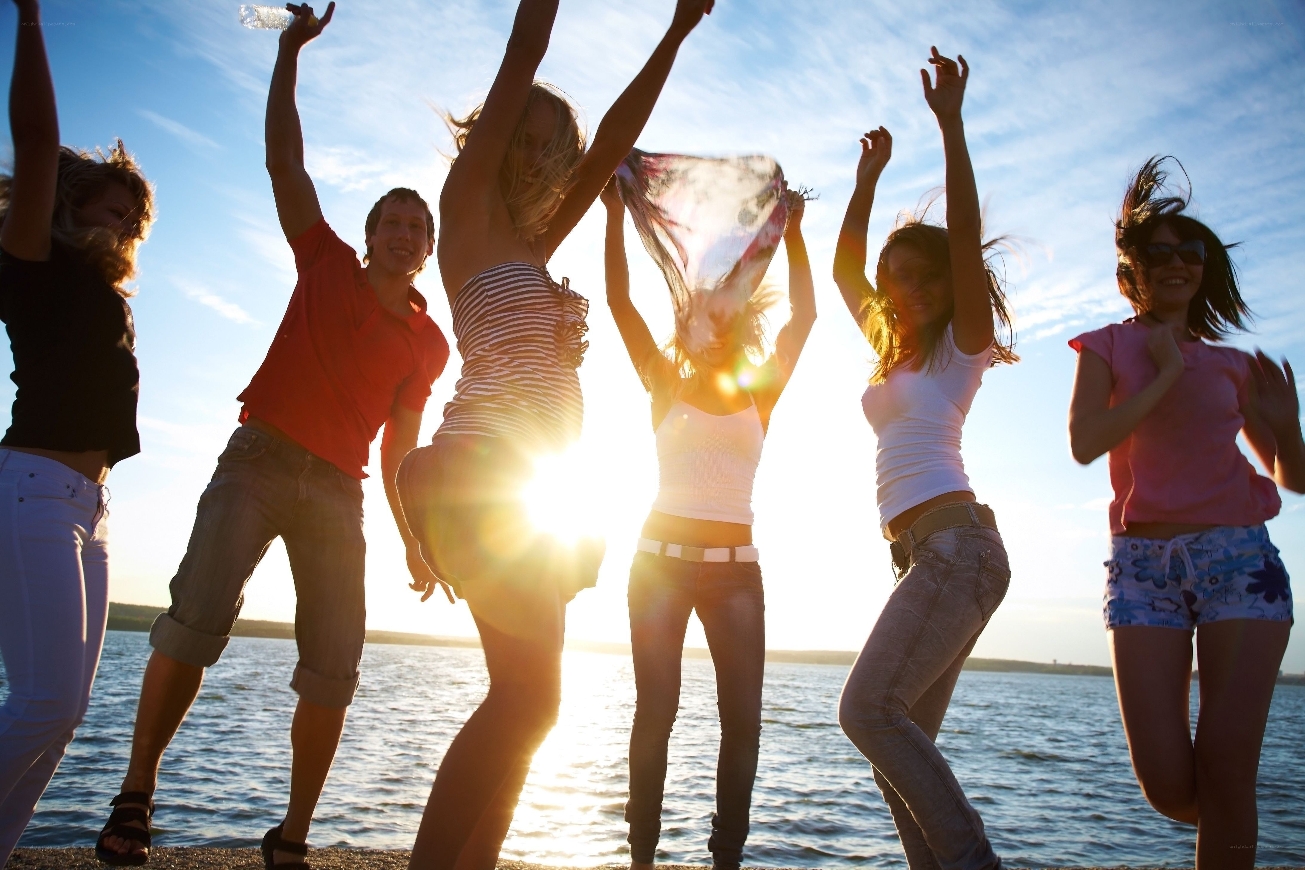friends dancing by the water