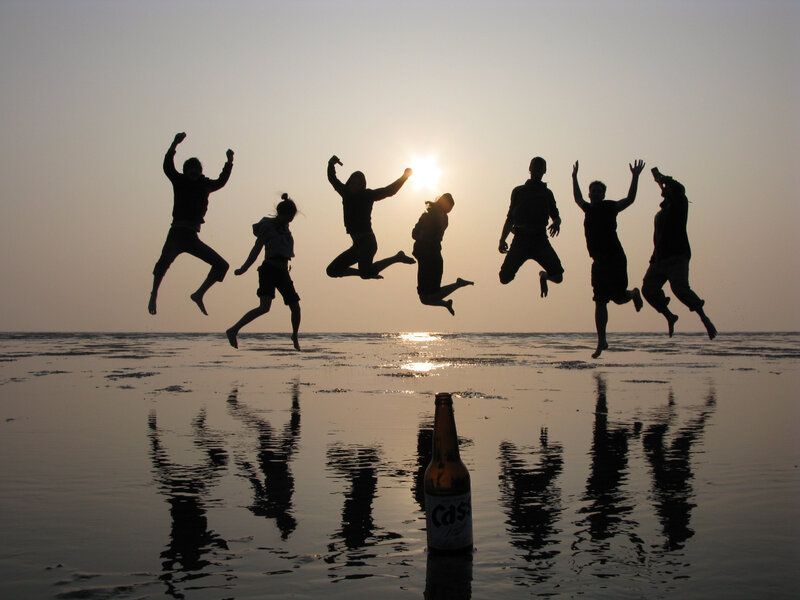 Friends jumping at sunset on beach
