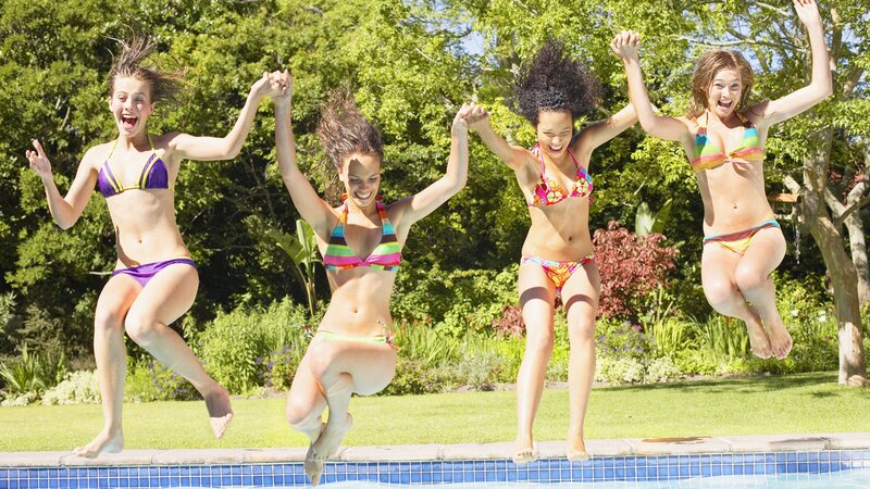 Friends jumping into pool
