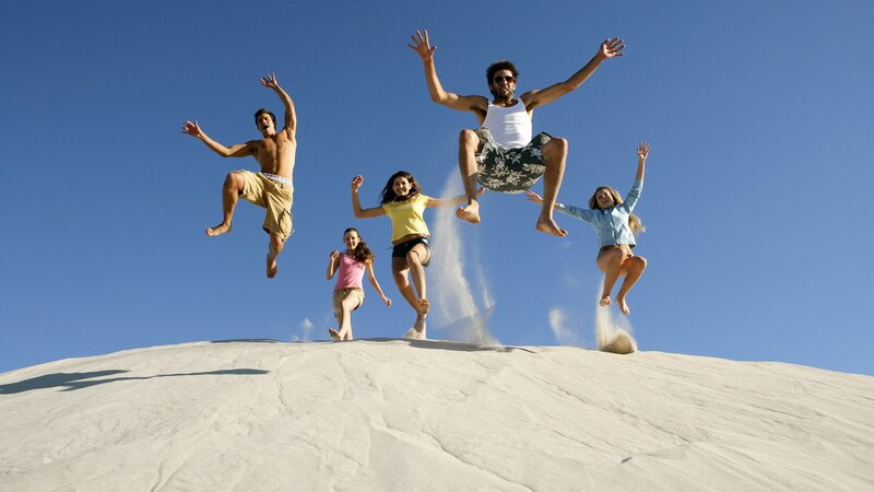 Friends jumping on a sand dune
