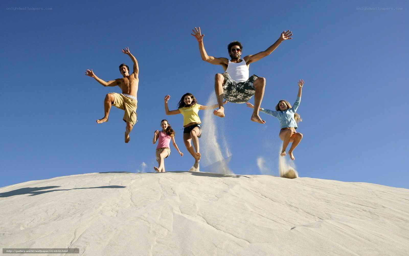 Friends jumping on a sand dune
