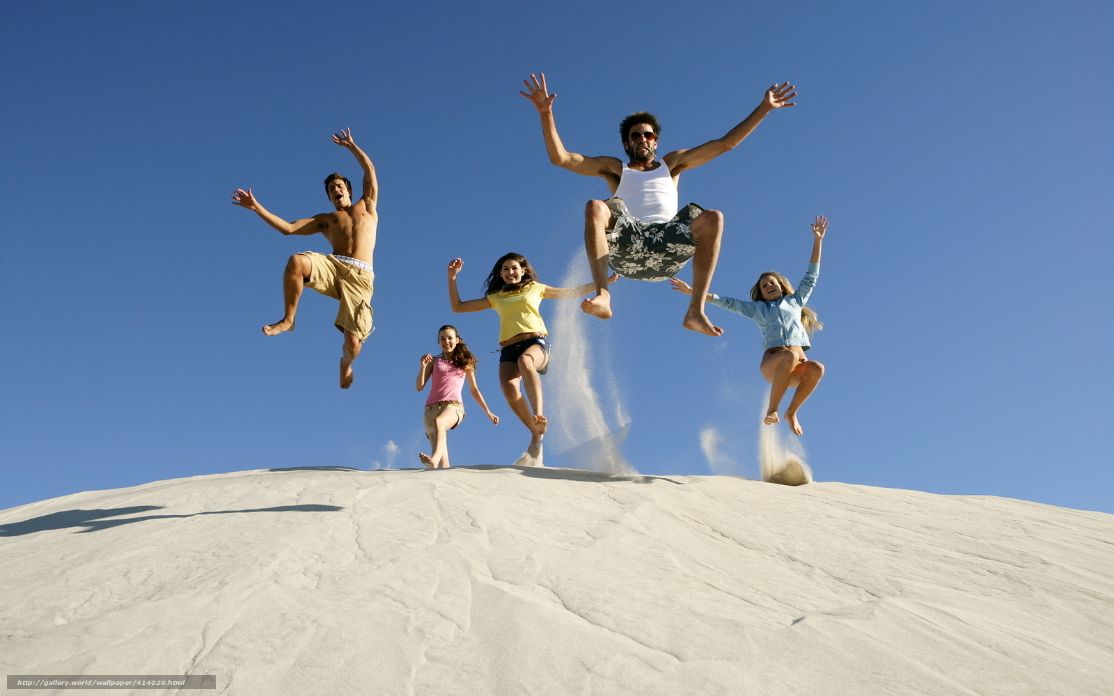 Friends jumping on a sand dune