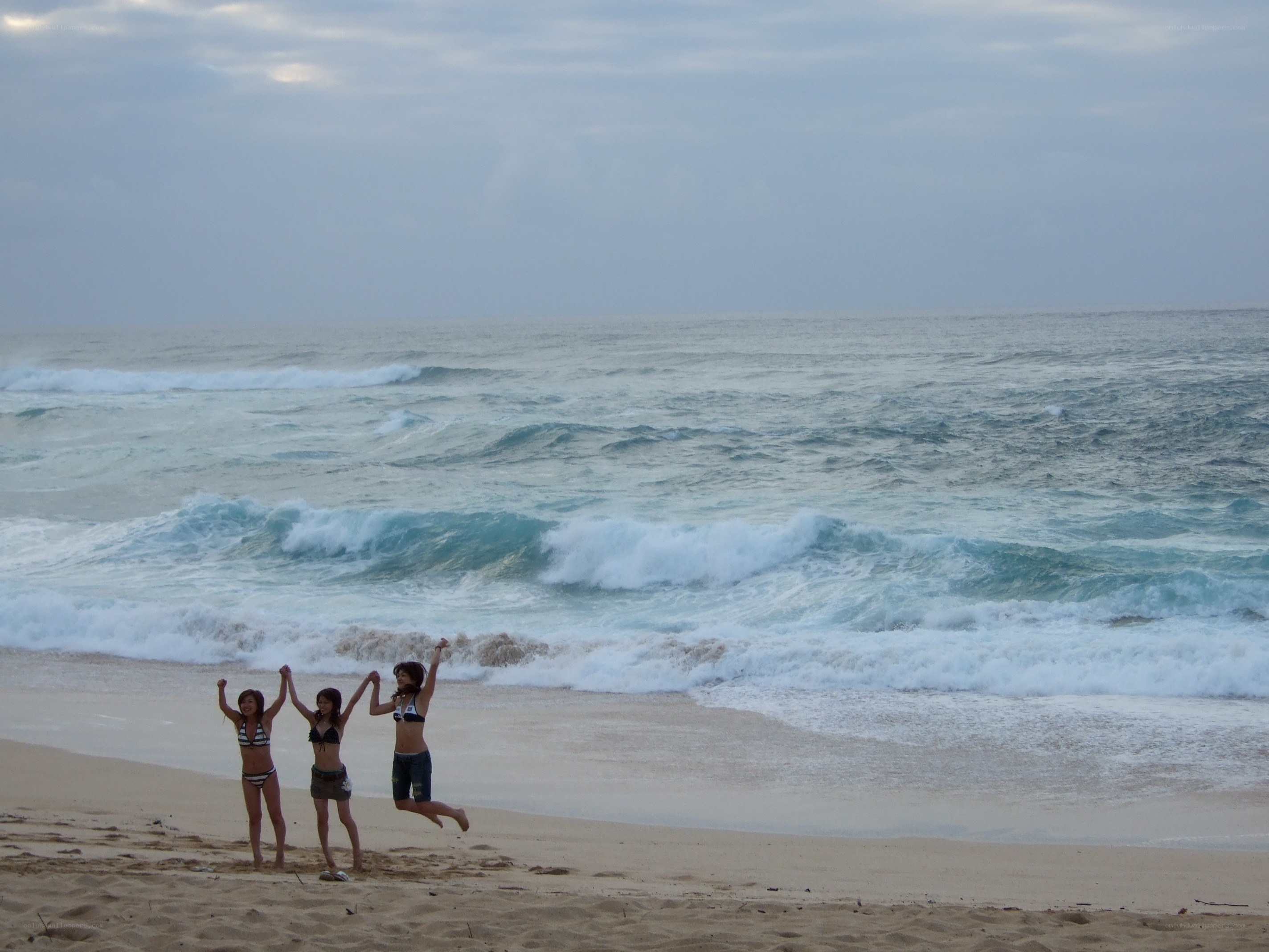 Friends jumping on the beach