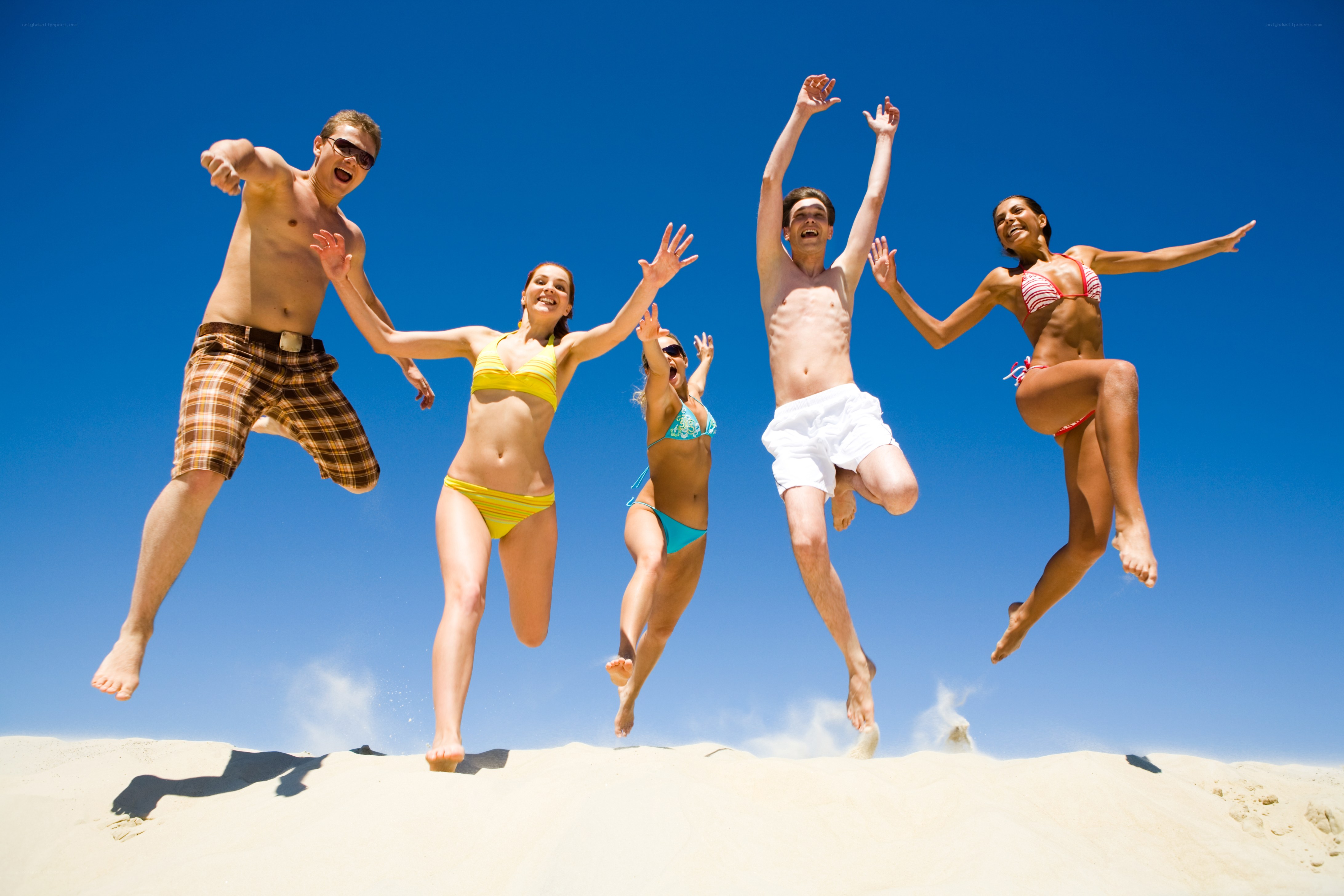 Friends jumping on the beach