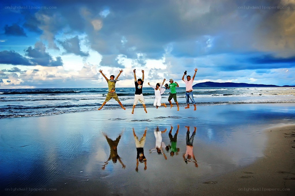 Friends jumping on the beach