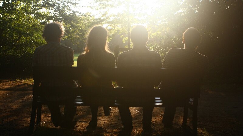 Friends on a bench at sunset