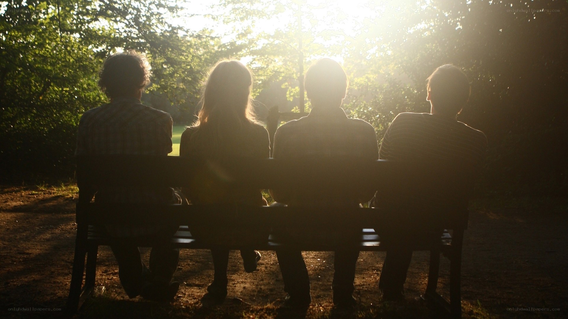 Friends on a bench at sunset