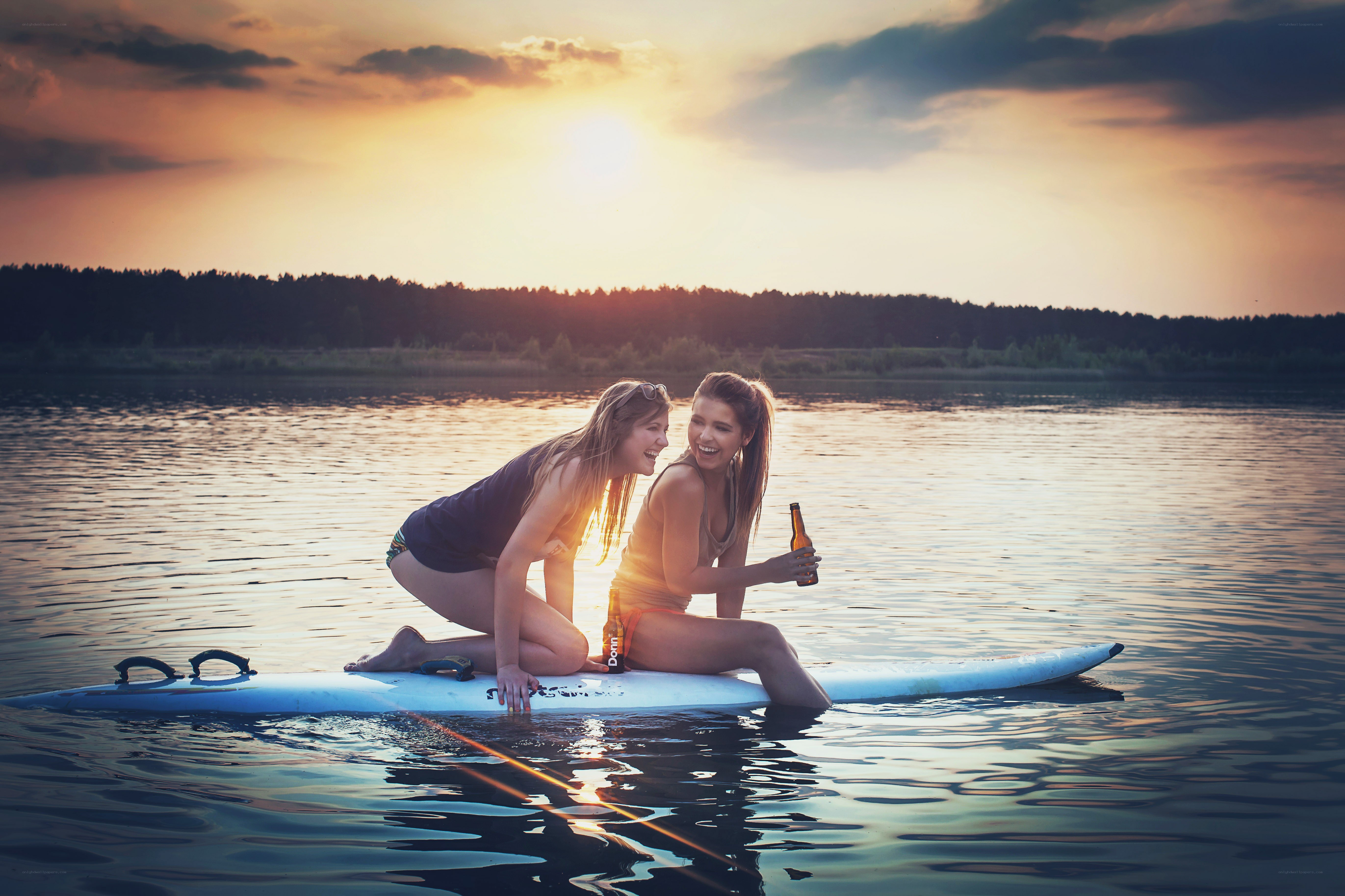 Friends on paddleboard at sunset