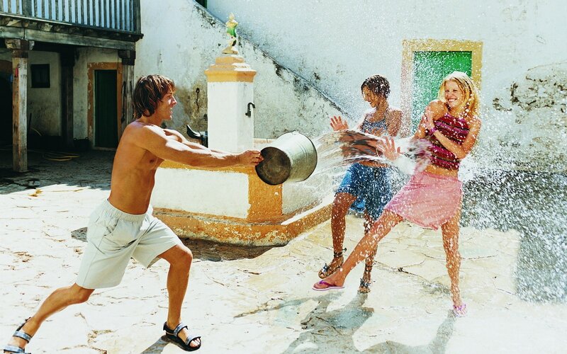 Friends playing with water in courtyard