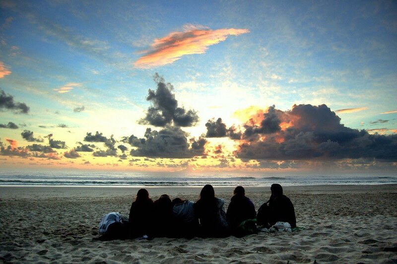 Friends watching sunset on the beach