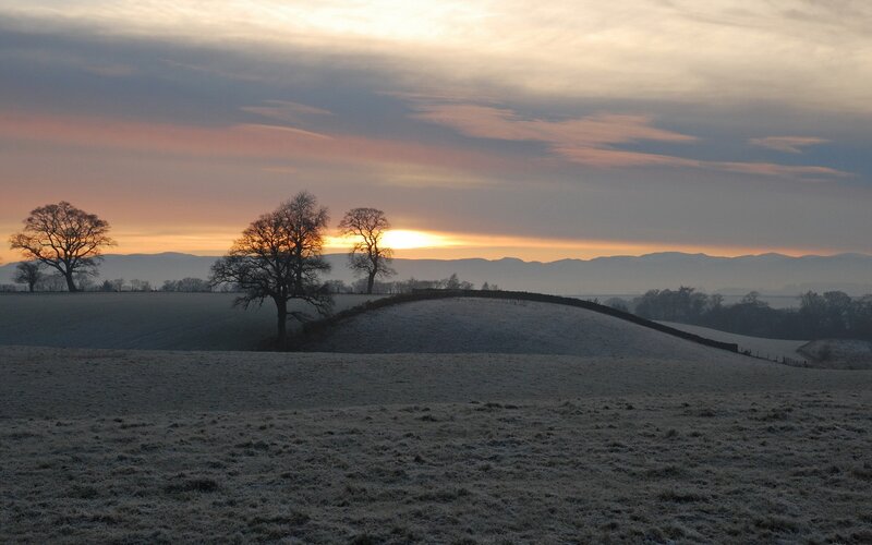 Frosty sunrise over rolling hills