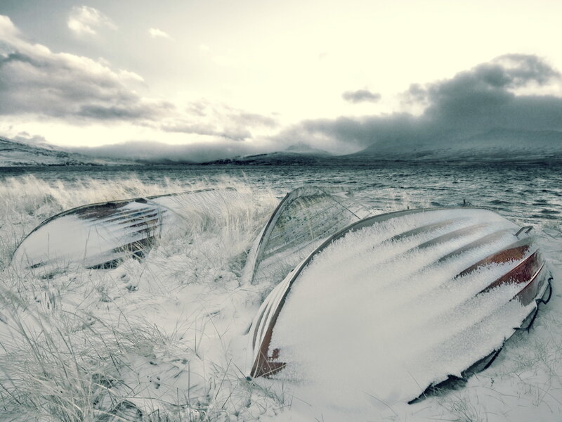 Frozen boats on a snowy shore