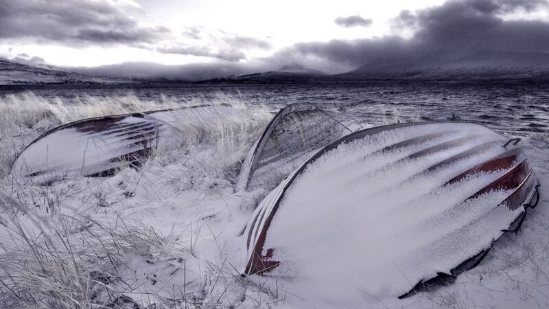 Frozen boats on a snowy shore