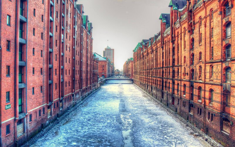 Frozen Canal Between Brick Buildings