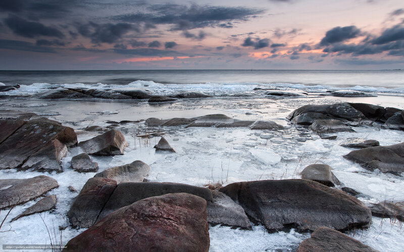 Frozen coastal rocks at sunset