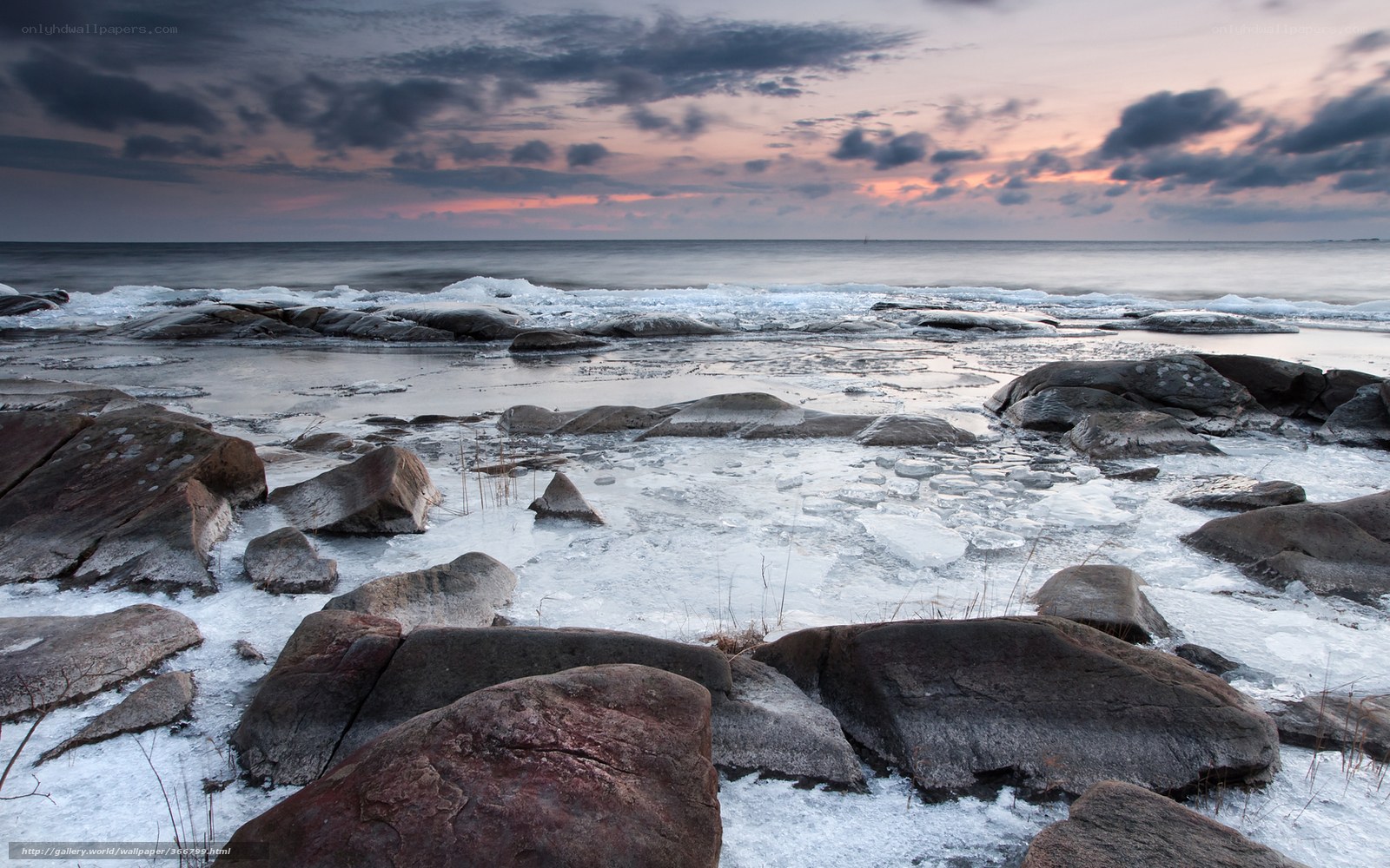 Frozen coastal rocks at sunset